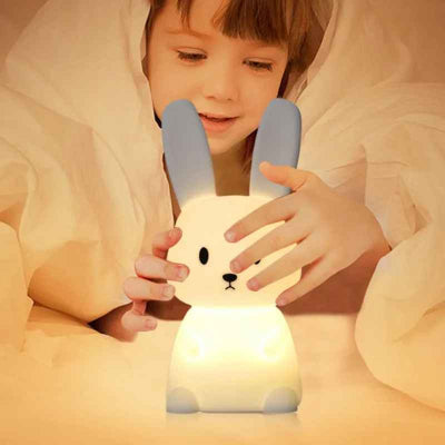 veilleuse bébé lumapin avec garçon jouant avec sa veilleuse dans son lit